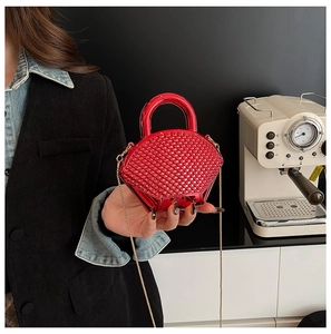 Detail of red rhinestone mini evening bag with gold chain and studded acrylic finish