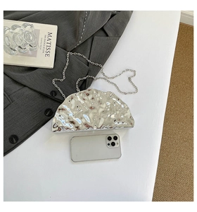 Macro view of silver acrylic evening bag with ice-crack texture and metal chain