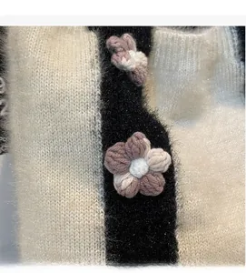 Close-up of knit tote bag featuring plush texture and handcrafted pink crochet flower detail