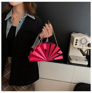 Detailed view of fuchsia fan-shaped clutch bag with pleated metallic finish and gold chain