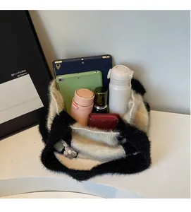 Intérieur spacieux d'un grand sac en maille noir et blanc contenant tablettes et gourdes