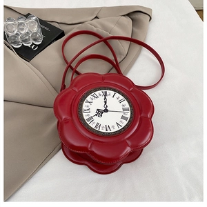 Macro shot of red flower-shaped clock handbag on a blazer with elegant artistic props