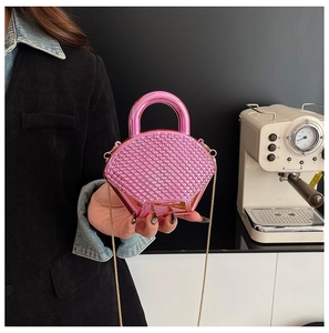 Detail of rose pink rhinestone mini box bag with metallic handle and gold chain