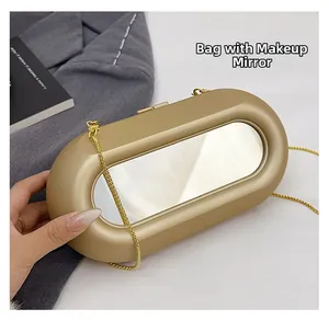 Detail of gold oval box clutch bag featuring a built-in mirror and fine metal chain