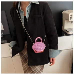 Chic pink metallic mini bag with woven texture and gold chain strap shown on a model