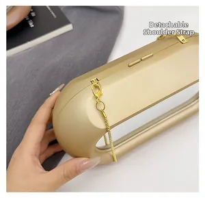 Detail of champagne gold acrylic box bag with detachable gold chain strap and smooth finish