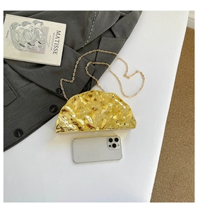 Golden acrylic shell bag with ice crack pattern and detachable chain shown with accessories