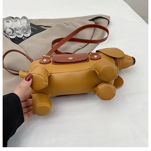 Detail of dachshund dog-shaped shoulder bag in yellow PU leather with magnetic metal buckle