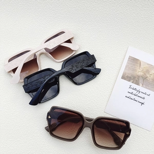 Détail de lunettes de soleil oversize avec monture gaufrée et verres dégradés
