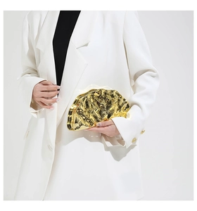 Detailed view of luxury gold shell evening bag with unique crinkle liquid texture