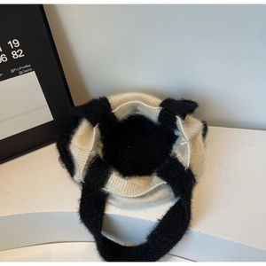 Détail du sac à main en tricot avec texture mohair douce et design contrasté noir et blanc