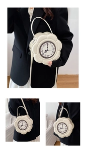 Detail of white petal-shaped bag showing the vintage clock face and silver hardware