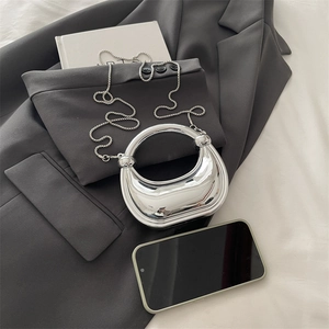 Mini silver crescent moon acrylic clutch bag with chain strap shown on blazer