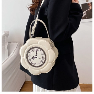 Close-up of beige clock-shaped purse with Roman numerals and petal edges on a model
