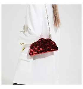 Detail of red mirror chain bag with liquid texture on a model wearing a white suit