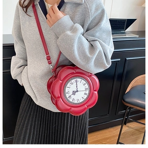 Close-up of red flower-shaped crossbody bag featuring a vintage clock face design