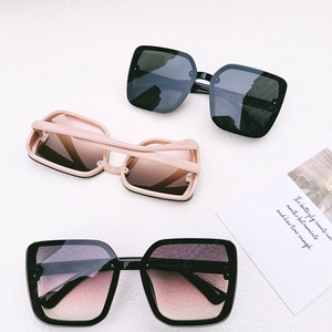 Close-up of oversized square sunglasses in black and pink with model specs on temples