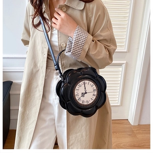 Detailed view of the vintage clock dial and flower shape on the black PU crossbody bag