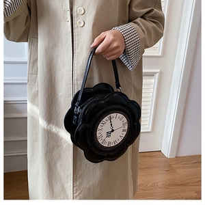 Detail of black flower-shaped clock handbag with Roman numerals and hand strap