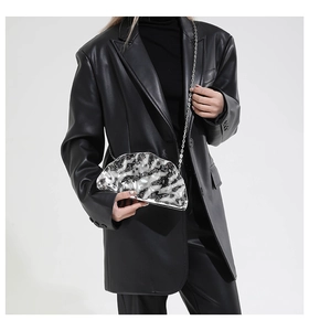 Detail of a silver metallic evening clutch with ice-cracked texture and chain strap