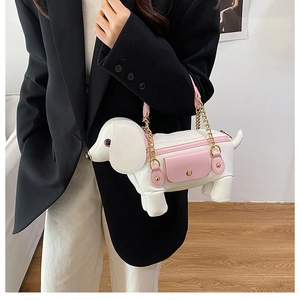 Détail du sac à bandoulière chiot rose et blanc avec bandoulière en chaîne dorée