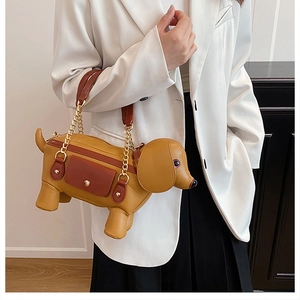 Detail of dachshund-shaped handbag featuring ginger leather and gold metal chain strap