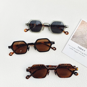 Three pairs of stylish hexagonal sunglasses in gray, black, and tortoise shell frames
