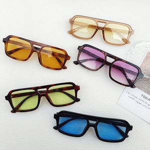 Flat lay of vintage double-bridge sunglasses with colorful lenses and rectangle frames