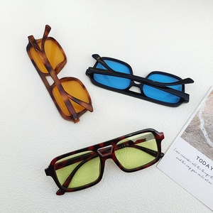 Flat lay of vintage square sunglasses in tortoiseshell and black with colorful lenses