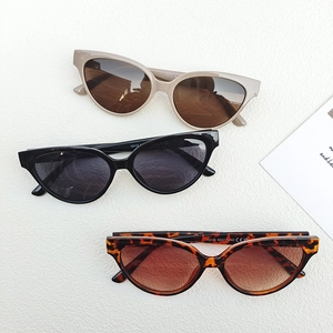Three pairs of vintage cat-eye sunglasses in beige, black, and tortoiseshell frames