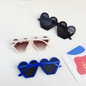 Vue détaillée de lunettes de soleil géométriques cœur en noir, crème et bleu royal