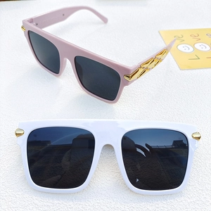 Macro detail of large frame sunglasses with gold geometric patterns and temple engravings