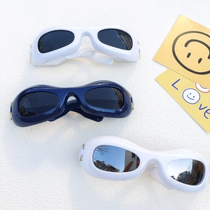Retro Y2K oval sunglasses with thick frames and metal hinges on textured surface