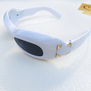 Macro shot of white Y2K sunglasses featuring gold rivets and textured quilted arms