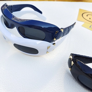 Detail of quilted texture temples and golden triangle rivets on stacked sunglasses