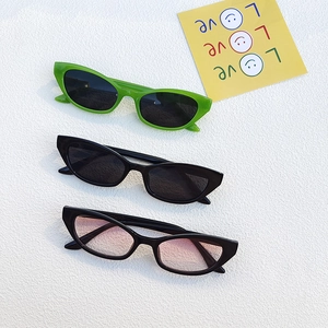 Three retro cat-eye sunglasses in green, black, and pink gradient displayed on a white texture