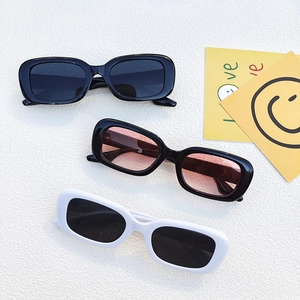 Three pairs of vintage rectangle sunglasses in black, pink, and white frame colors