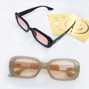 Chic rectangular sunglasses in black and beige with gradient lenses on white stone