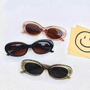 Trois paires de lunettes de soleil ovales vintage en ambre, noir et vert olive sur blanc