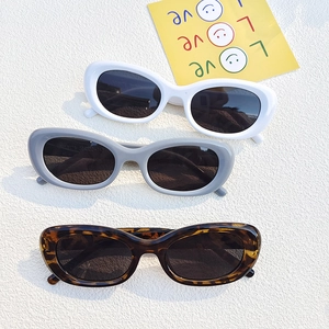 Retro oval sunglasses set in white, grey, and tortoise shell with thick frames