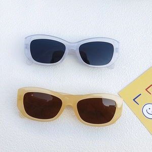 Retro cat-eye sunglasses with lavender and beige frames on a textured backdrop
