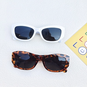 Vintage small cat-eye sunglasses in white and tortoiseshell frames with dark lenses