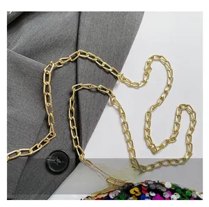Detail of gold metal chain strap and colorful sequins on luxury evening box clutch