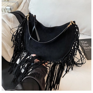 Detailansicht der schwarzen Wildledertasche mit langen Fransen und Goldbeschlägen