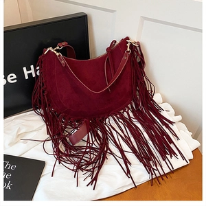 Nahaufnahme der burgunderroten Hobo-Tasche aus Wildlederimitat mit Fransen und Goldbuckle