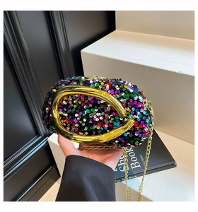 Detailed close-up of colorful sequins and gold oval metal handle on a stylish evening clutch