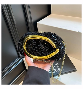 Detail of black sequin evening bag featuring a gold horseshoe handle and metal chain strap