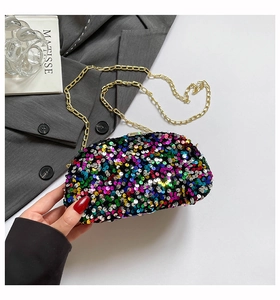 Detail of colorful sequins evening bag with gold chain strap on a grey suit background