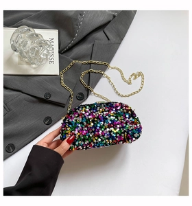 Macro shot of colorful sequins and gold chain strap on the evening clutch bag