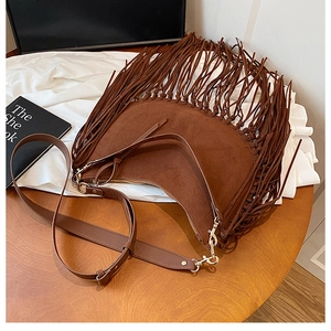 Nahaufnahme einer braunen Wildleder-Hobotasche mit Fransen und Vintage-Metallteilen